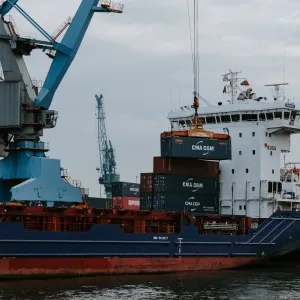 Cargo vessel and loading crane at a port